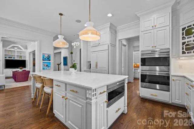 a kitchen with kitchen island a stove a table and chairs