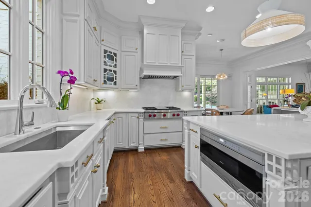 a kitchen with granite countertop a sink stainless steel appliances and cabinets