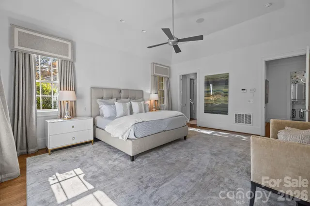 a spacious bedroom with a large bed and a chandelier