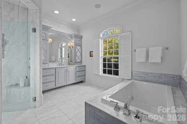 a spacious bathroom with a tub sink and mirror