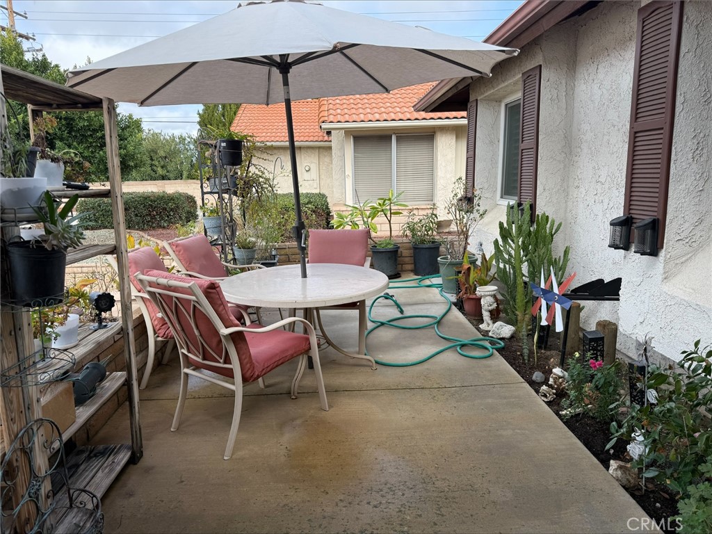 1114 Bottle Tree Way Hemet, CA 92545 - Photo 23 of 23 a patio with tables and chairs under an umbrella