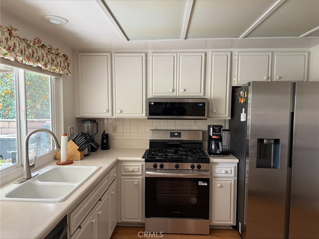 1114 Bottle Tree Way Hemet, CA 92545 - Photo 9 of 23 a kitchen with a sink stove and refrigerator