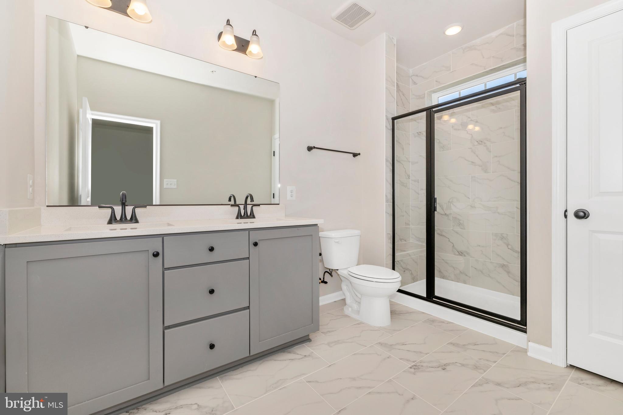 103 Spring Bank Way Frederick, MD 21701 - Photo 12 of 13 a bathroom with a double vanity sink toilet mirror and shower