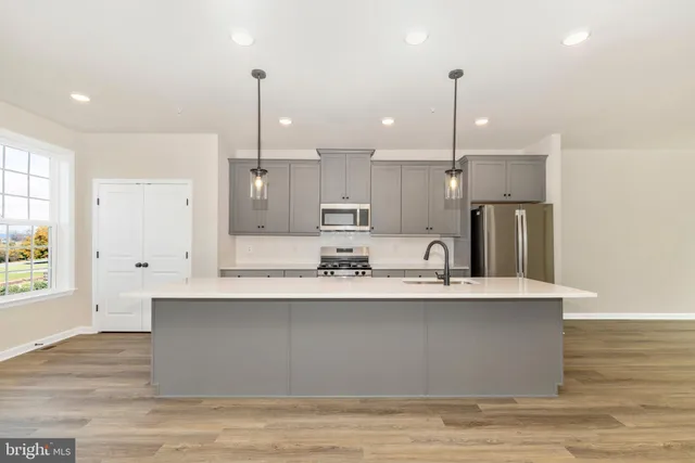 a kitchen with stainless steel appliances granite countertop a sink a stove and a refrigerator