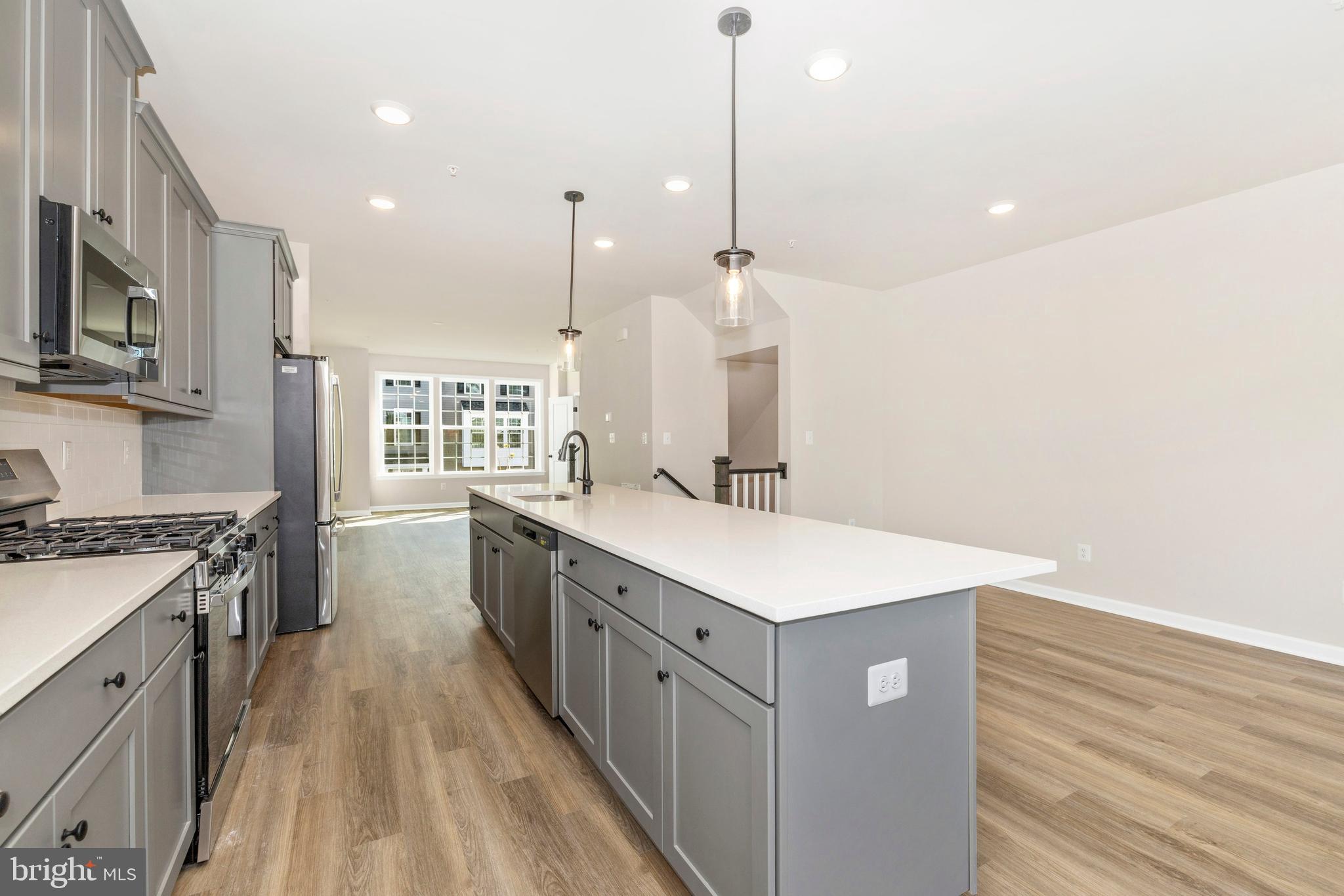 103 Spring Bank Way Frederick, MD 21701 - Photo 8 of 13 a kitchen with stainless steel appliances granite countertop a sink a stove and a wooden floor