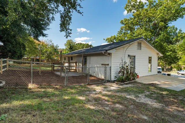 a view of backyard of house with wooden deck and seating space