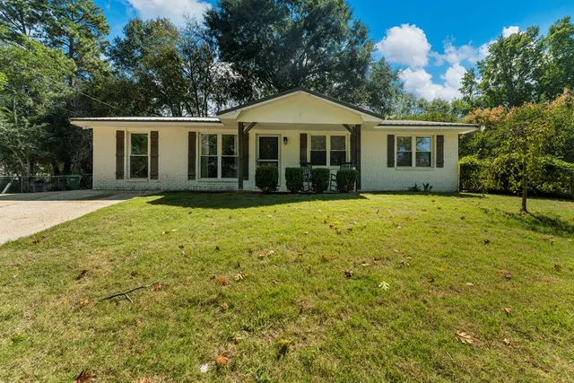 a front view of a house with a garden