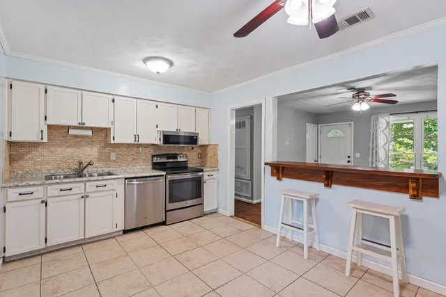 a kitchen with granite countertop white cabinets and white appliances