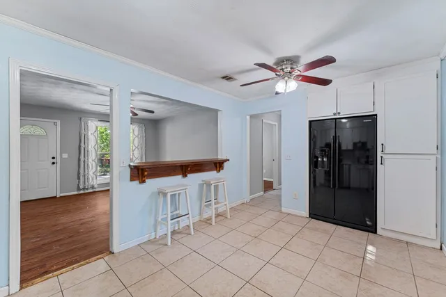 a view of a kitchen with a refrigerator and a stove top oven