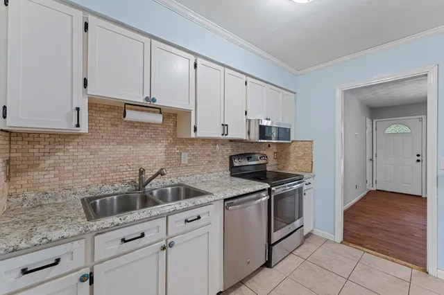 a kitchen with stainless steel appliances granite countertop a sink and a stove