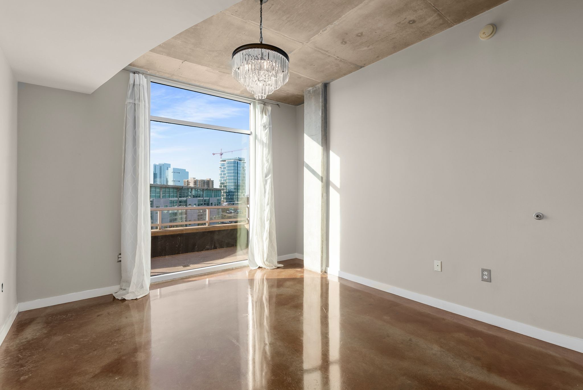 600 12th Avenue South, Unit 829 Nashville, TN 37203 - Photo 11 of 32 a view of a livingroom with wooden floor and a chandelier
