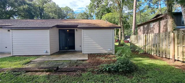 a view of a house with a small yard plants and large tree