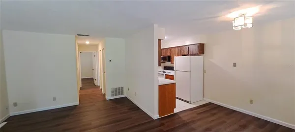 an empty room with wooden floor and cabinet