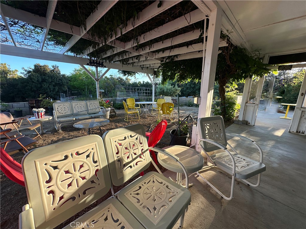 29820 Chihuahua Valley Road Warner Springs, CA 92086 - Photo 32 of 75 a view of a patio with table and chairs potted plants and floor to ceiling window with wooden floor