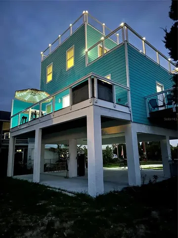 a front view of a house with lots of green space and plants
