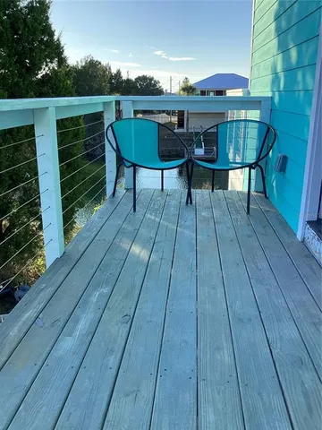 a view of deck with table and chairs a barbeque with wooden floor and fence