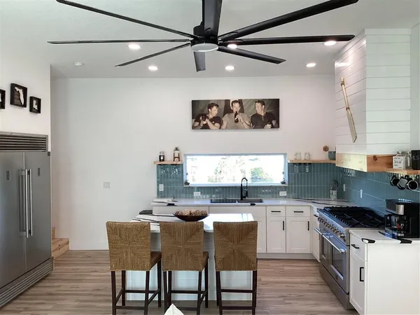 a kitchen with stainless steel appliances granite countertop a sink a stove and a refrigerator