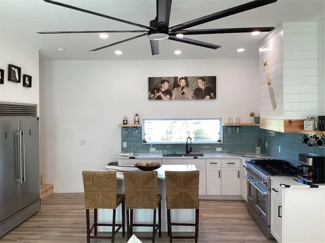 a kitchen with stainless steel appliances granite countertop a sink a stove and a refrigerator