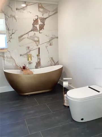 a white bath tub sitting next to a white toilet