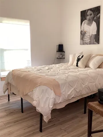 a bedroom with a bed and a painting on the wall