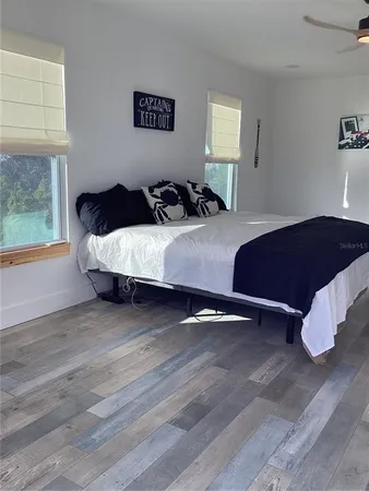 a bedroom with a bed and wooden floor