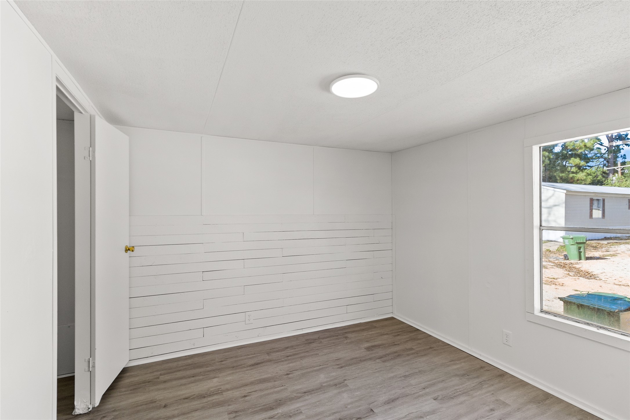1202 Highway 190, Unit 16 Huntsville, TX 77340 - Photo 11 of 23 an empty room with wooden floor and windows