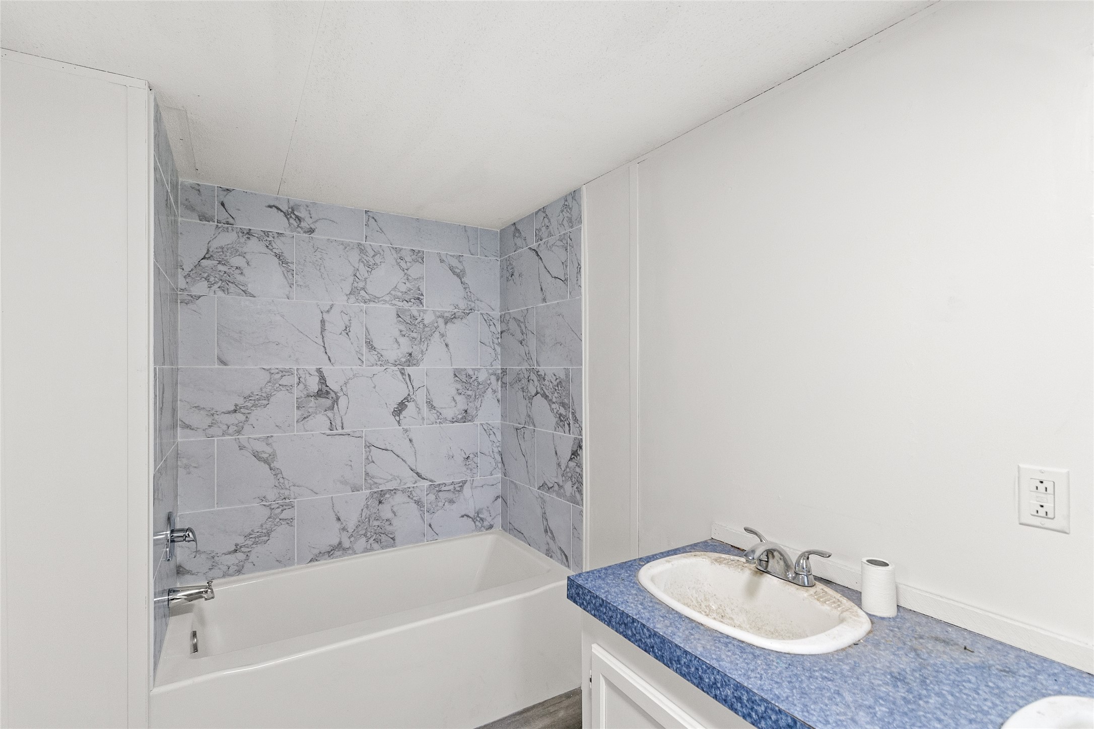 1202 Highway 190, Unit 16 Huntsville, TX 77340 - Photo 18 of 23 a bathroom with a granite countertop sink and a bathtub