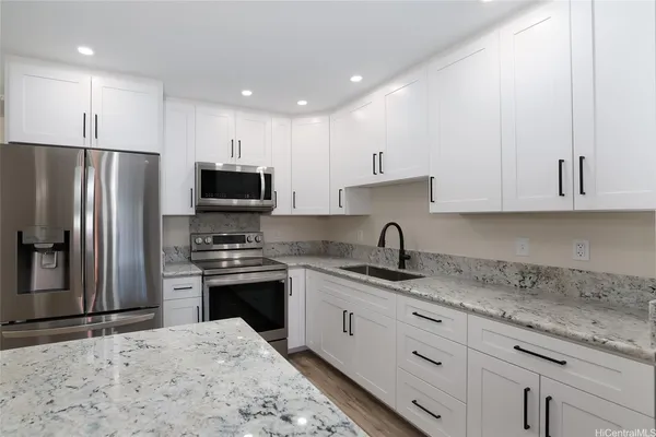 a kitchen with stainless steel appliances granite countertop a sink stove and refrigerator