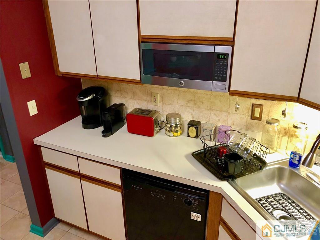 910 Meadow Court, Unit 910 Helmetta, NJ 08828 - Photo 14 of 43 a kitchen with a sink a stove and cabinets