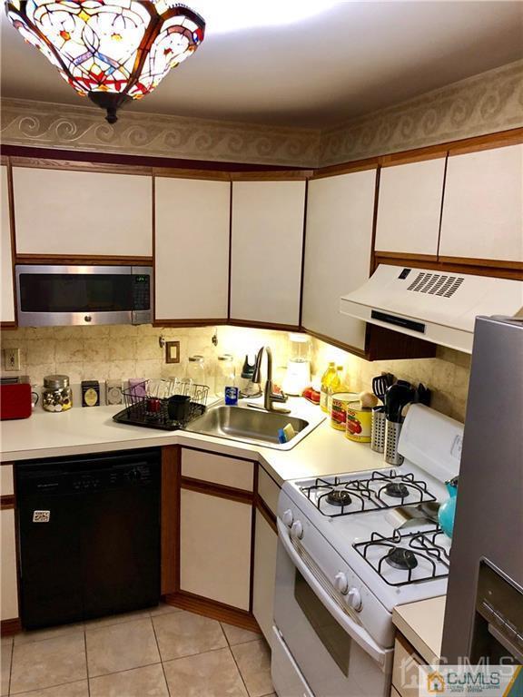 910 Meadow Court, Unit 910 Helmetta, NJ 08828 - Photo 16 of 43 a kitchen with a stove a sink and a microwave