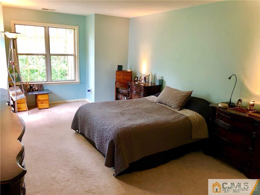 910 Meadow Court, Unit 910 Helmetta, NJ 08828 - Photo 27 of 43 a bedroom with a bed and wooden floor