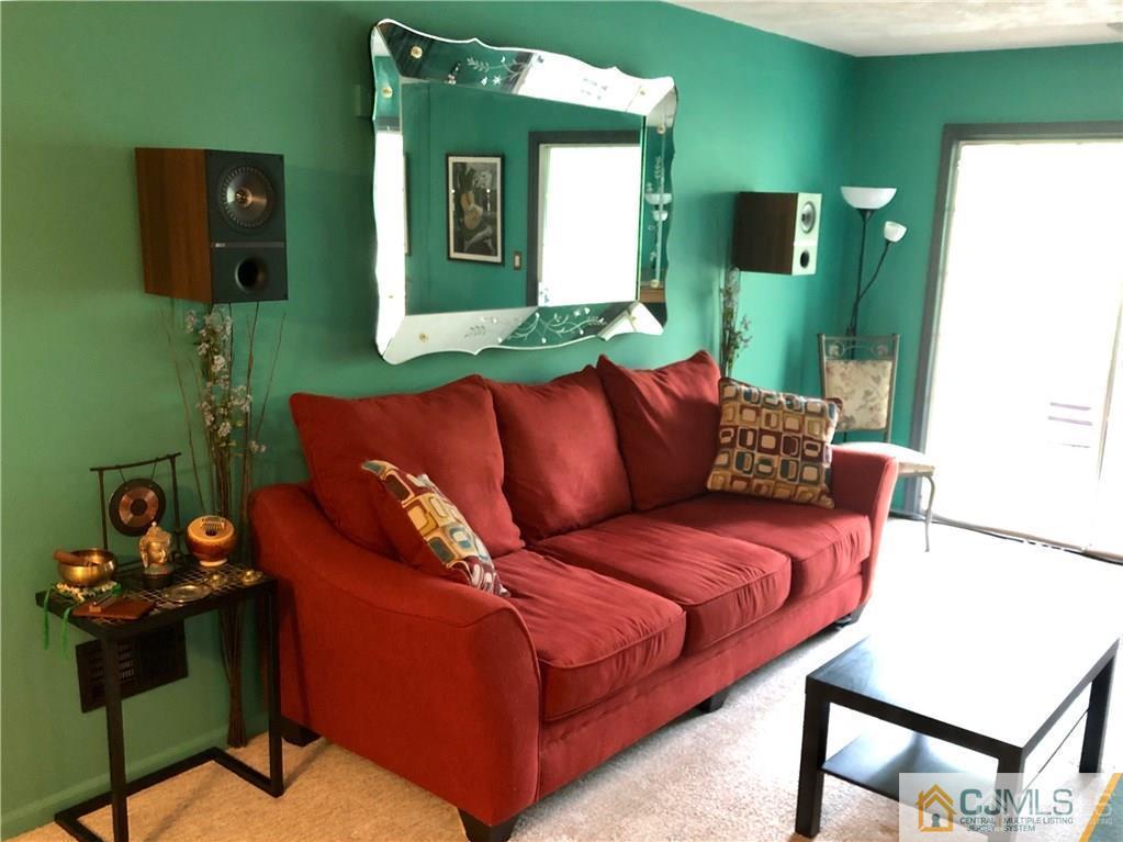 910 Meadow Court, Unit 910 Helmetta, NJ 08828 - Photo 6 of 43 a blue couch sitting in a living room next to a window
