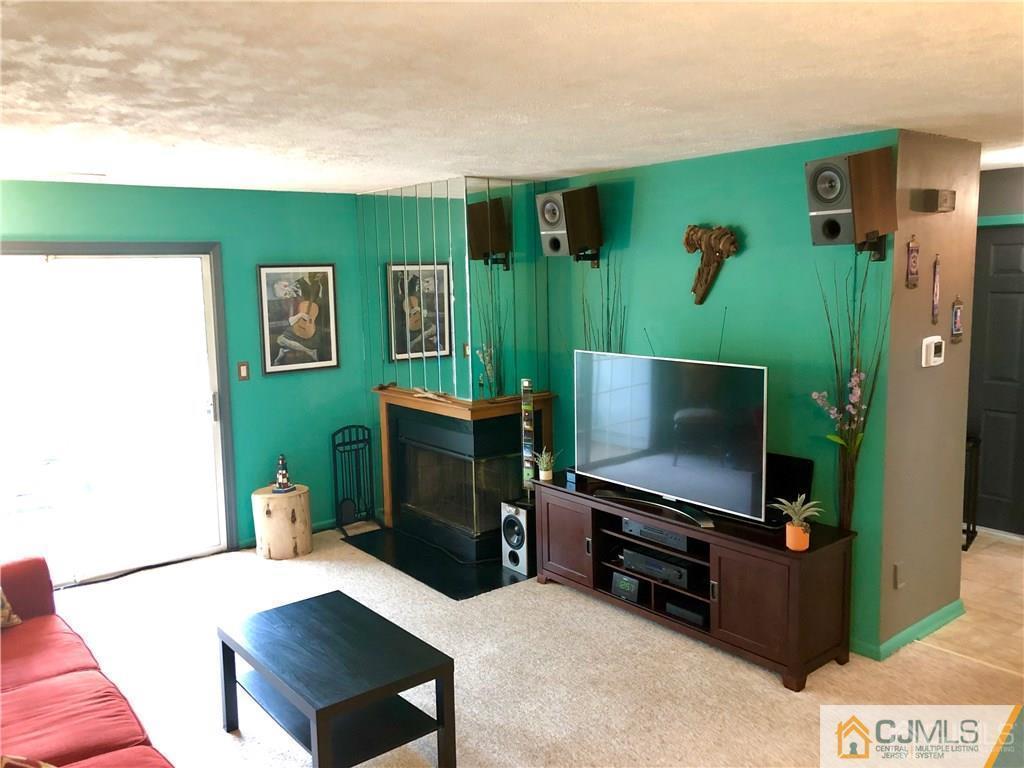 910 Meadow Court, Unit 910 Helmetta, NJ 08828 - Photo 7 of 43 a living room with furniture and a flat screen tv