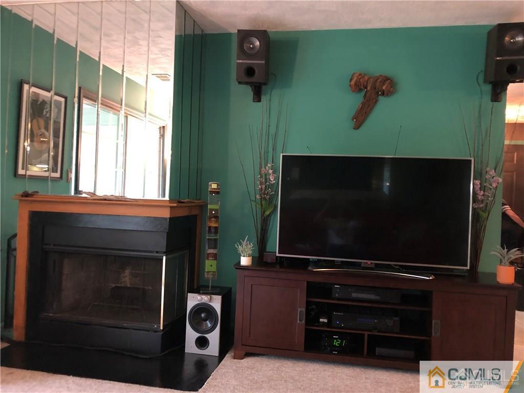 910 Meadow Court, Unit 910 Helmetta, NJ 08828 - Photo 10 of 43 a living room with a flat screen tv and a fireplace