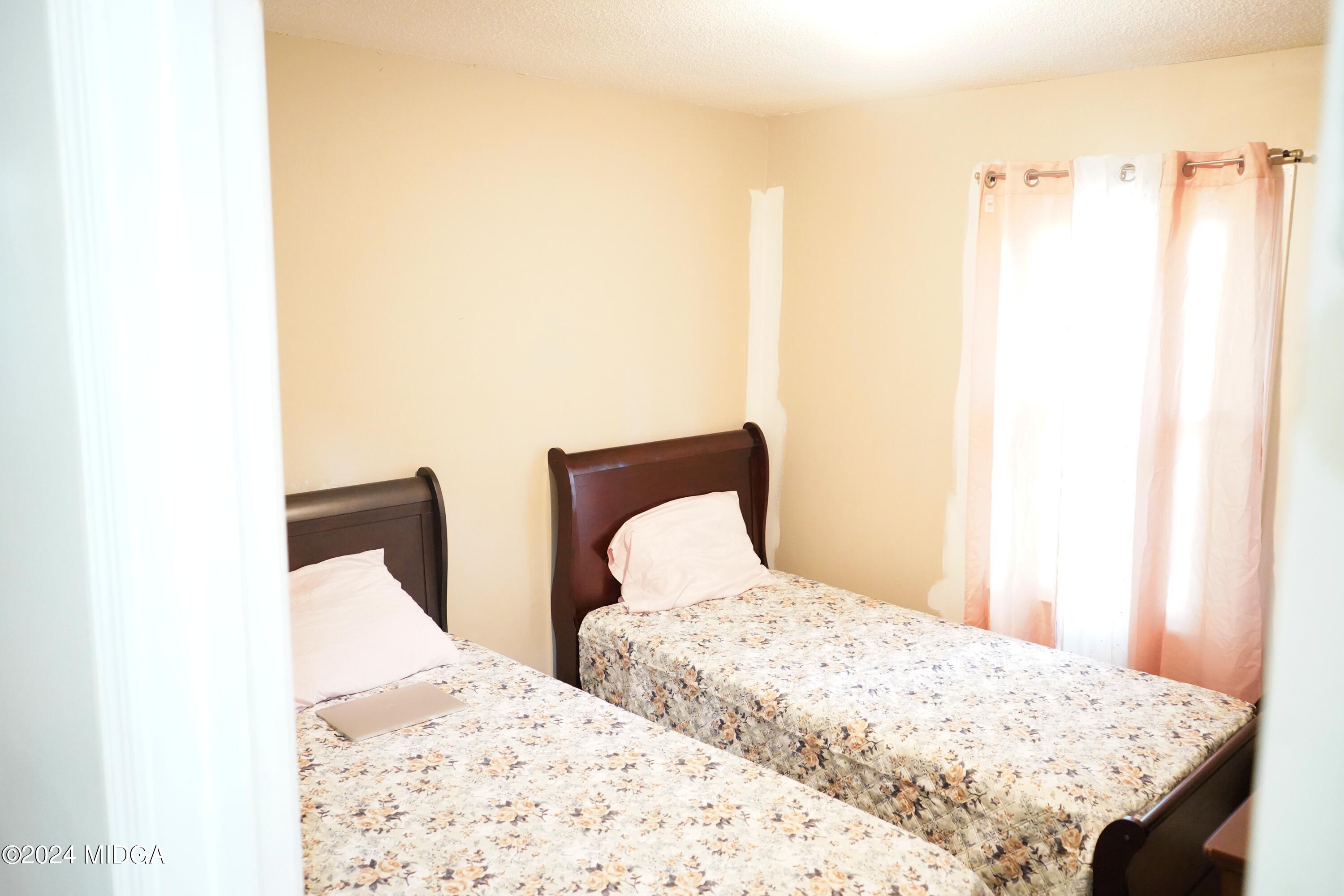 1082 Old Cabaniss Road Forsyth, GA 31029 - Photo 14 of 14 a bedroom with two bed and a window