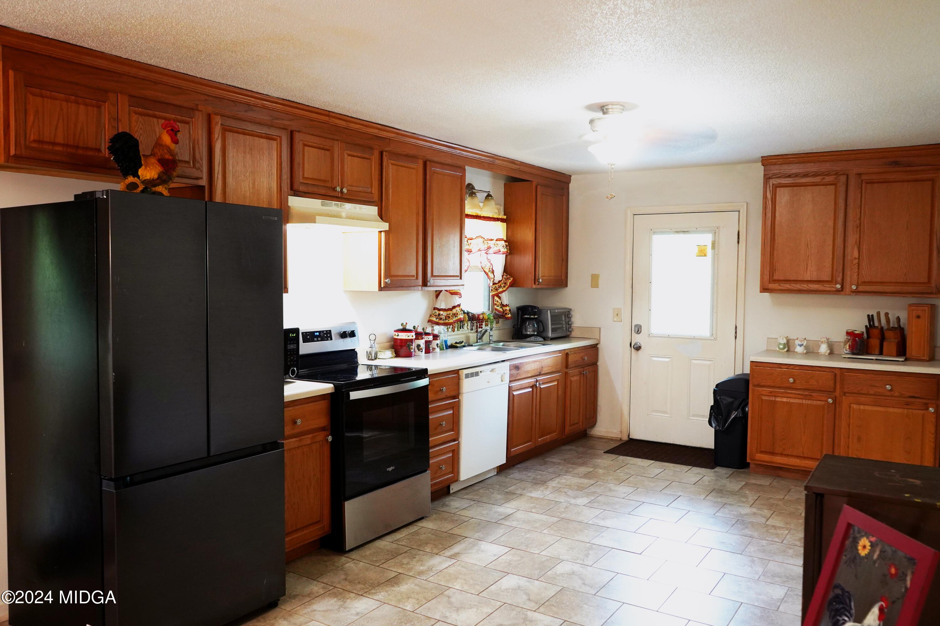1082 Old Cabaniss Road Forsyth, GA 31029 - Photo 6 of 14 a kitchen with granite countertop a refrigerator stove top oven and sink