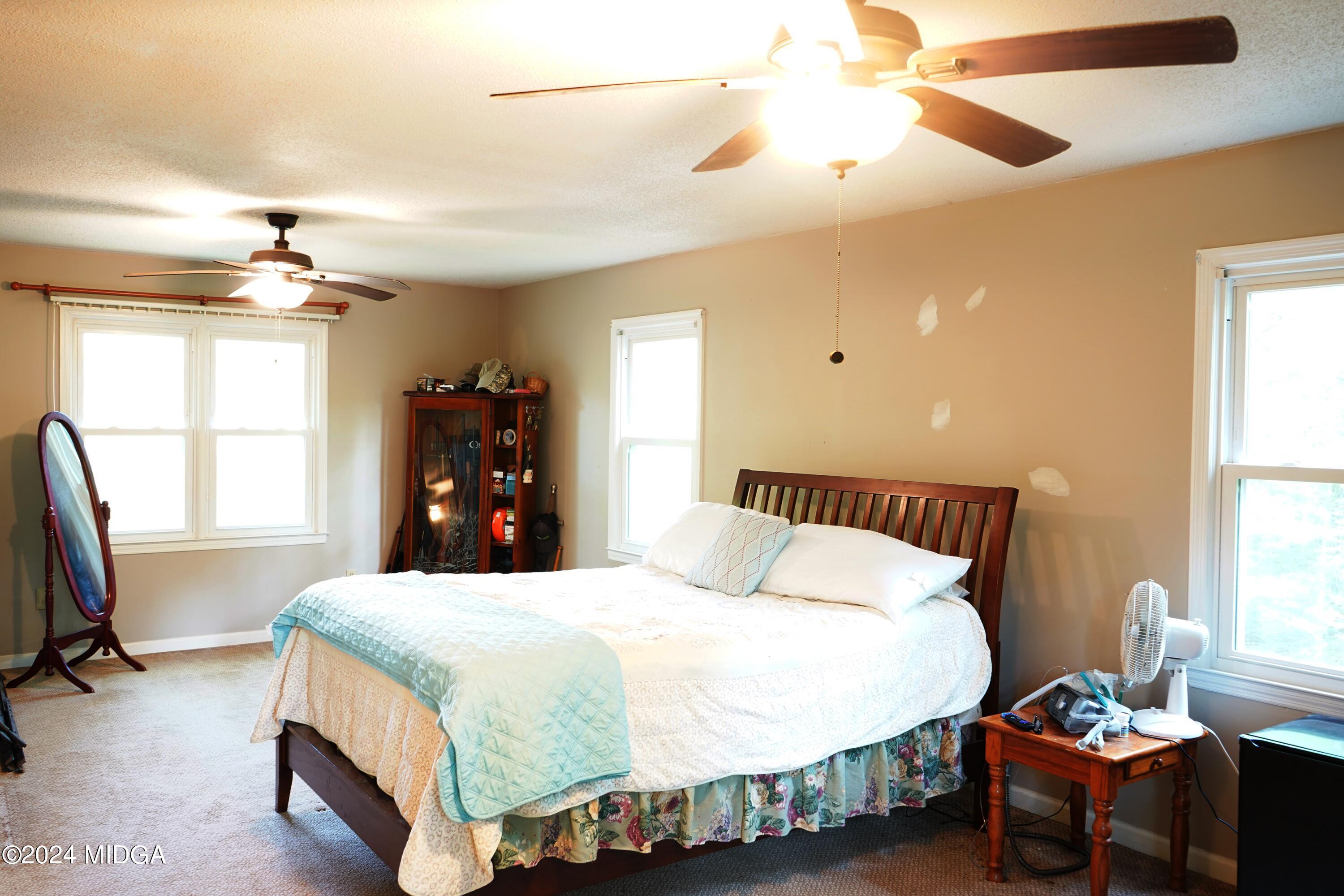 1082 Old Cabaniss Road Forsyth, GA 31029 - Photo 10 of 14 a bedroom with a bed and a chandelier