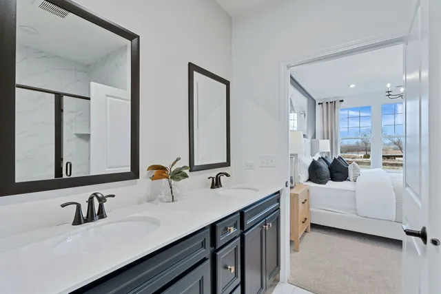 a bathroom with double vanity and a mirror