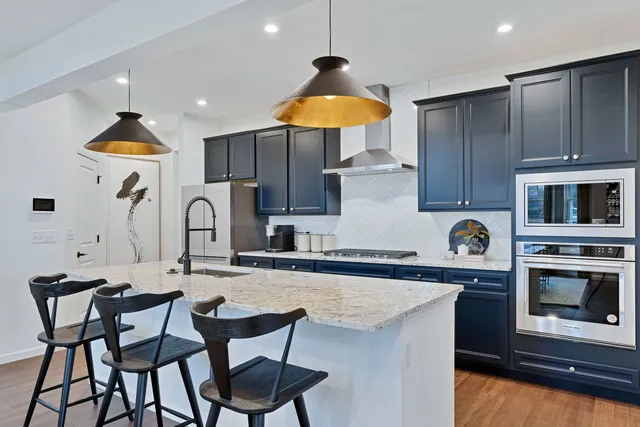 a kitchen with granite countertop a table chairs stove and cabinets