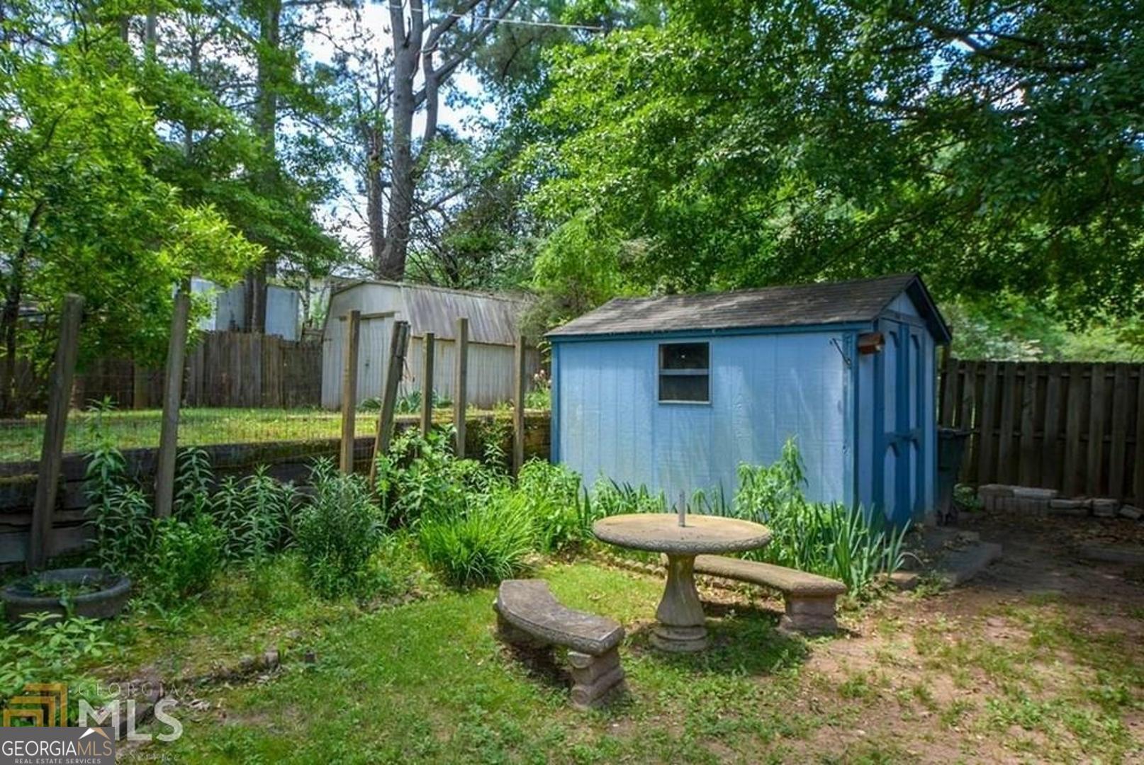110 Flint River Road Jonesboro, GA 30238 - Photo 4 of 18 a view of a backyard with table and chairs and wooden fence