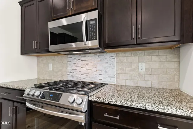 a kitchen with granite countertop stainless steel appliances and wooden cabinets