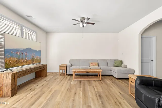 a view of a big room with wooden floor and windows