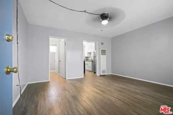 a view of a livingroom with wooden floor and a ceiling fan