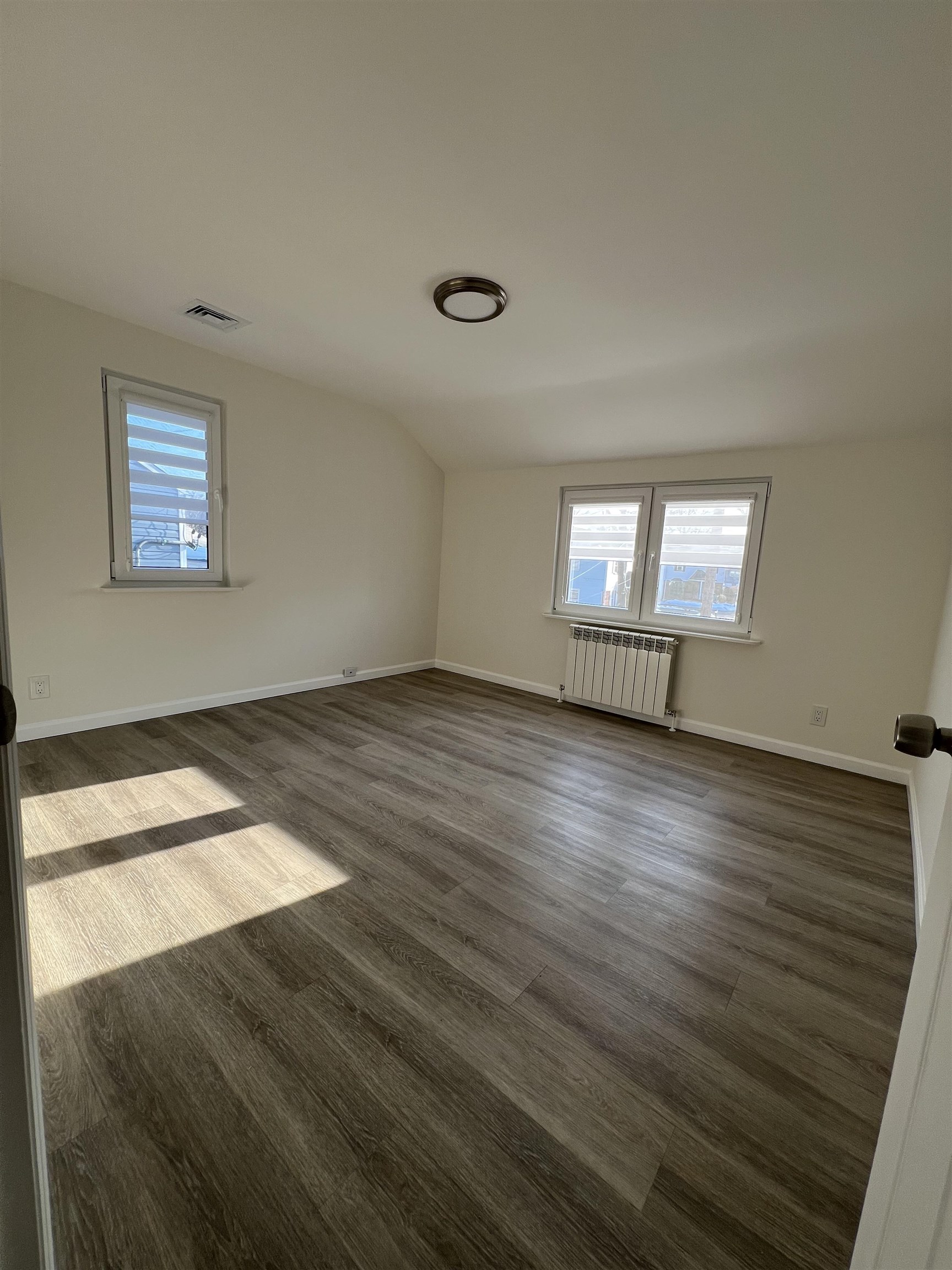 35 MacArthur Avenue, Unit 2 Hasbrouck Heights, NJ 07604 - Photo 11 of 14 an empty room with wooden floor and windows