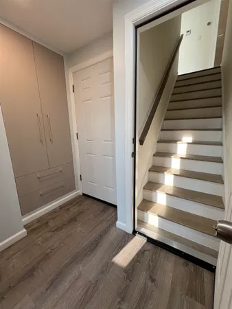 a view of a hallway with wooden floor and staircase