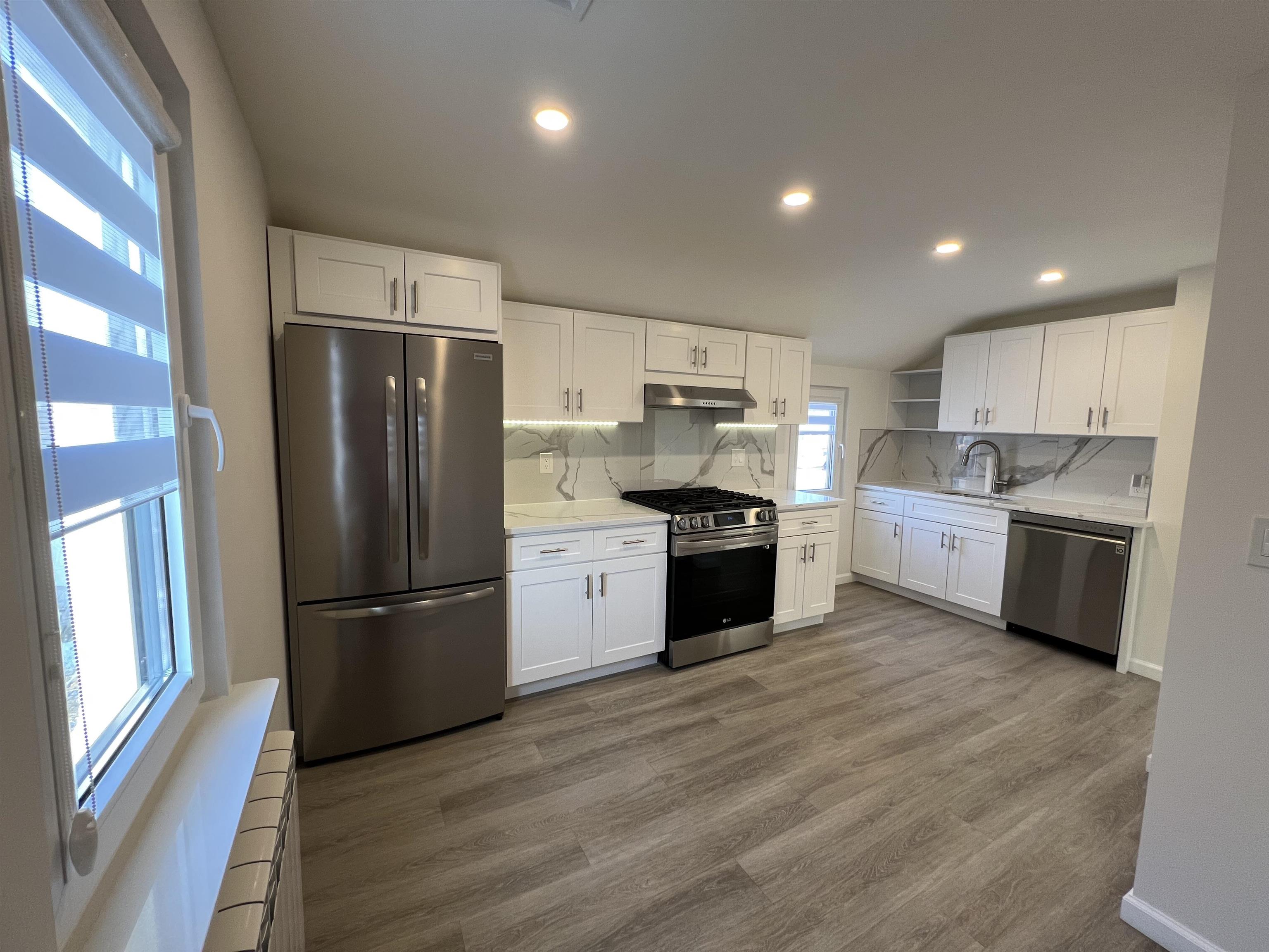 35 MacArthur Avenue, Unit 2 Hasbrouck Heights, NJ 07604 - Photo 6 of 14 a kitchen with stainless steel appliances a refrigerator sink and wooden floor