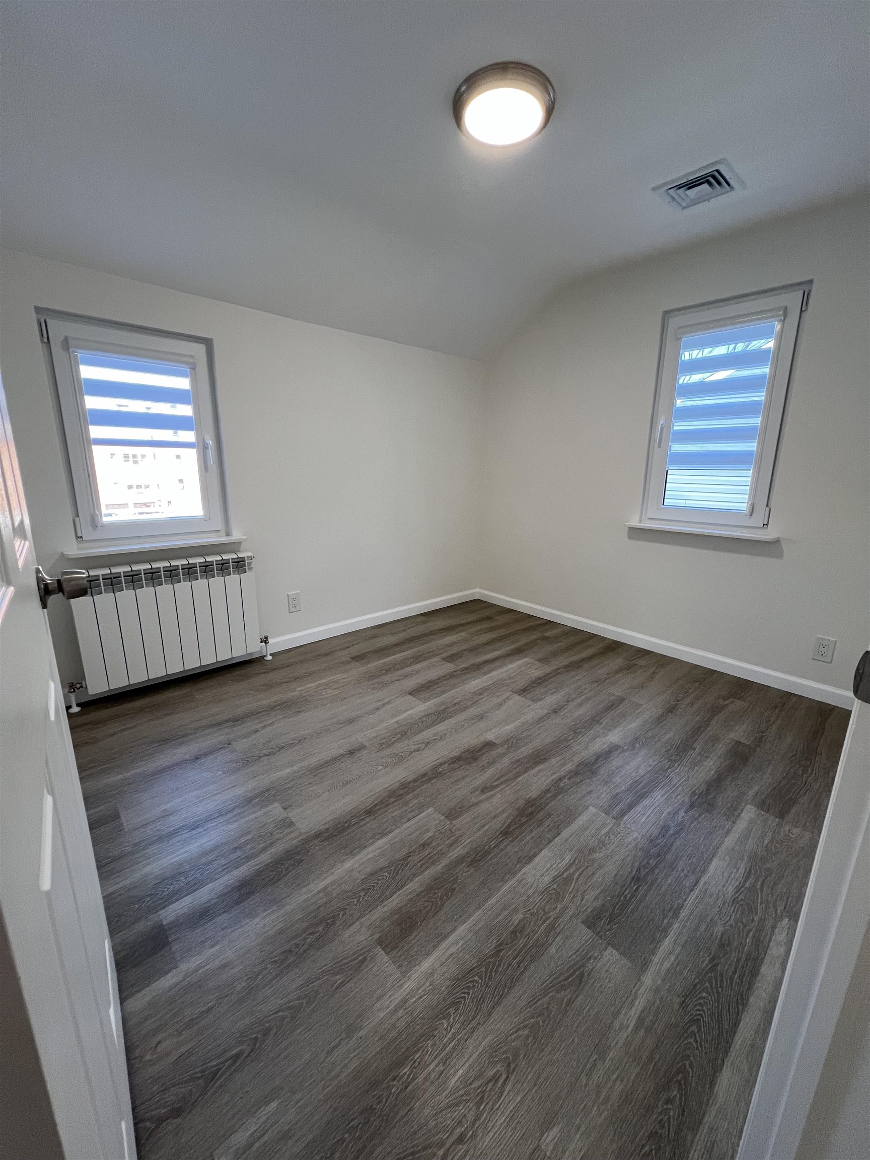 35 MacArthur Avenue, Unit 2 Hasbrouck Heights, NJ 07604 - Photo 9 of 14 wooden floor in an empty room with a window