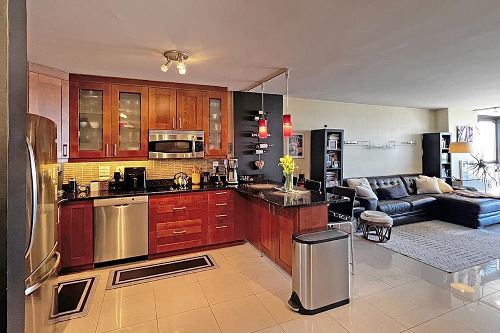 a kitchen with stainless steel appliances granite countertop a stove refrigerator and cabinets