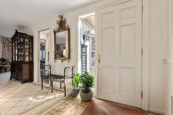 a view of a hallway with chairs and a potted plant