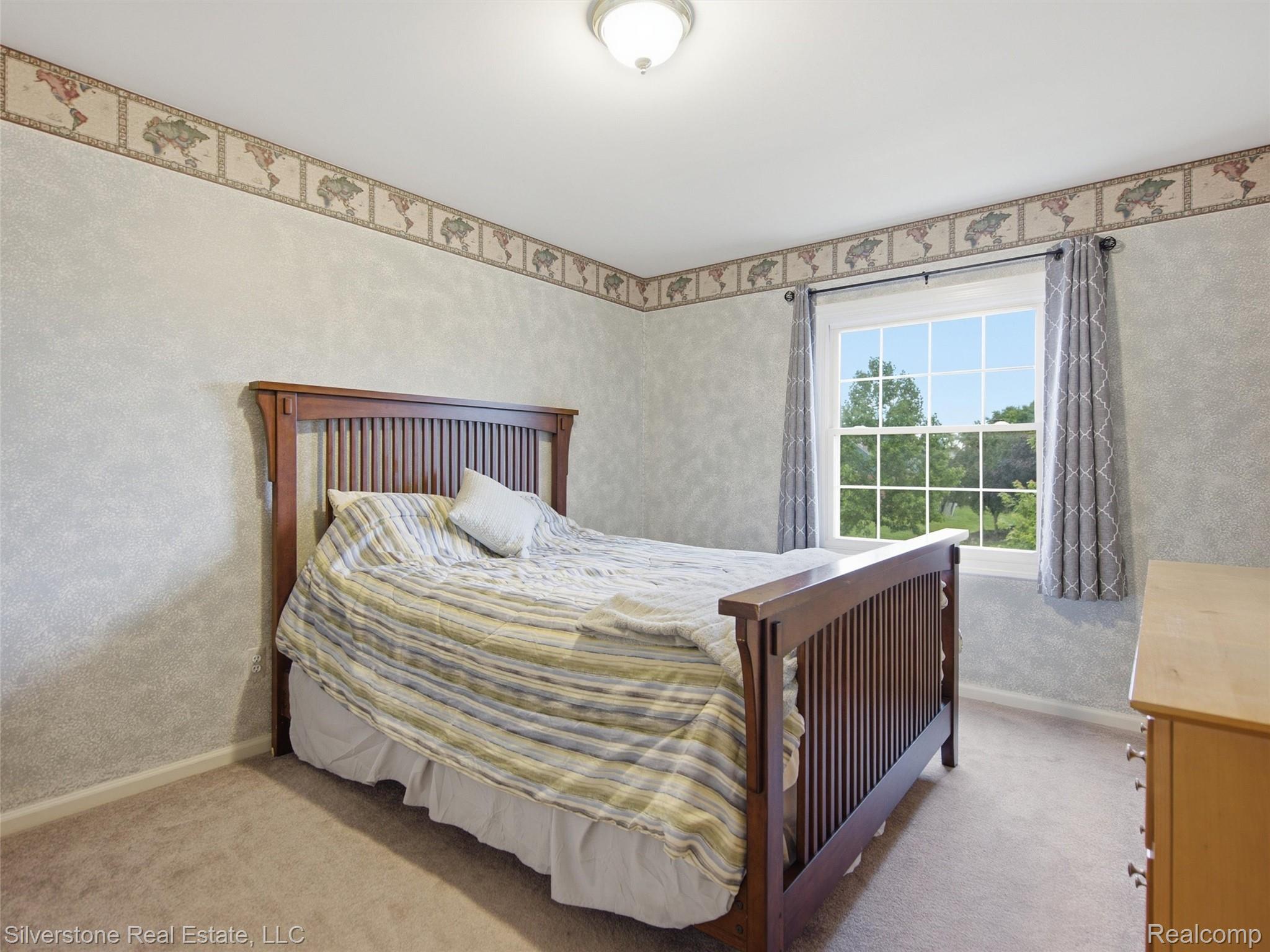 6577 Edith Court Troy, MI 48085 - Photo 41 of 61 Carpeted room featuring a double-hung window with exterior greenery, decorative wallpaper border, and a flush mount ceiling light